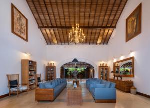 a living room with blue couches and a chandelier at The Colonial Escape in Galle