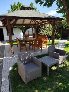 a wooden gazebo with chairs and a table and chairs at Noclegi Pod Lipami in Zwierzyniec