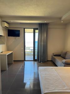 a room with a bed and a couch and a view of the ocean at nafsea in Afitos