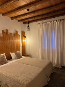 a bedroom with a large bed and a window at PANORAMIO in Batsi