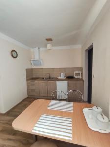 a kitchen with a wooden table and a table and chairs at Noclegi Pod Lipami in Zwierzyniec
