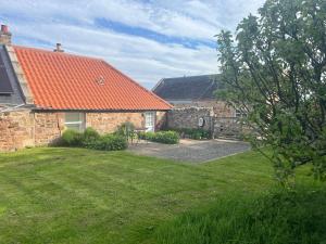 a house with an orange roof and a yard at The Wee Bothy at East Lothian Cottages in Lennoxlove