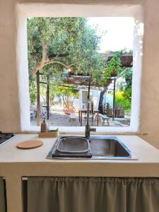 a kitchen with a sink and a window at Camping Fiori di Noto in Noto