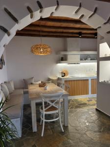 a dining room with a table and a kitchen at PANORAMIO in Batsi