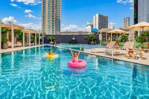 two people riding on an inner tube in a swimming pool at Millennium Central Downtown - Dubai in Dubai +47 photos