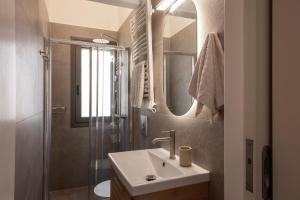 a bathroom with a sink and a shower at Villa Isabelle on the beach in Paralía Iríon +27 photos