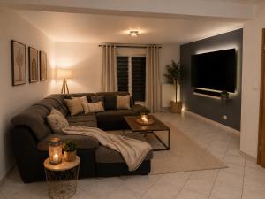 a living room with a couch and a table at 185 m duplex with pool near Strasbourg in Ittenheim