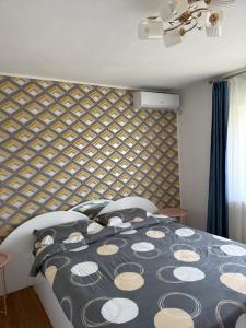 a bedroom with a bed with a patterned wall at Apartament Otopeni#Aeroport#Therme#Natatie in Otopeni