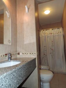 a bathroom with a sink and a toilet and a shower at Mareas Bajas in Las Grutas