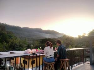 a man and a woman sitting at a table on a balcony at Bondoilampang in Ban Thung
