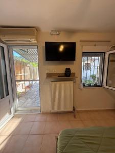 a living room with a flat screen tv on the wall at The Garden Studio AVLI Upper Vrasna in Nea Vrasna