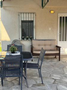 a patio with a table and chairs and a couch at The Garden Studio AVLI Upper Vrasna in Nea Vrasna +6 photos