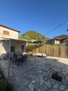 a patio with a table and chairs and a fence at The Garden Studio AVLI Upper Vrasna in Nea Vrasna