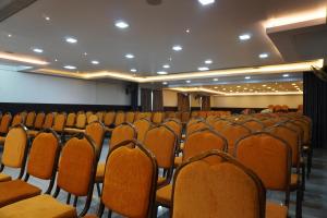 an empty auditorium with orange chairs in a room at HOTEL RUBY PALACE in Tiruchirappalli