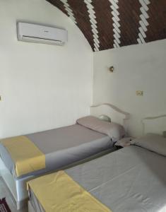 a room with two beds and a ceiling at Roma House in Aswan