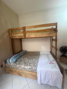 a wooden bunk bed in a room with a white sheet at Pousada cosmo in Uberaba