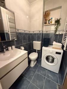 a bathroom with a toilet a sink and a washing machine at Apartman Vera in Brela +22 photos