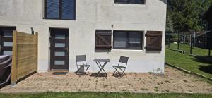 three chairs and a table in front of a building at Chez Rinner in Gellin