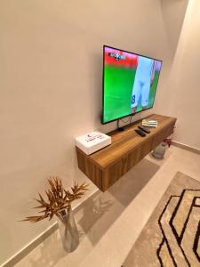 a flat screen tv sitting on a stand in a room at شقق حديثة موثثة in Dammam