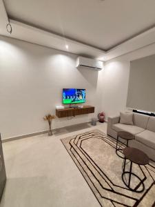 a living room with a couch and a flat screen tv at شقق حديثة موثثة in Dammam