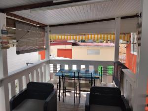a balcony with a table and chairs and a house at Charmant appart in Fort-de-France