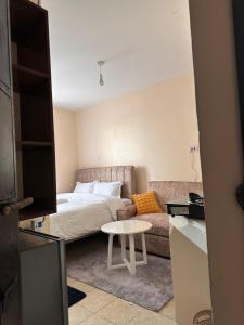 a bedroom with a bed and a couch and a table at Cool Studios, Machakos in Machakos
