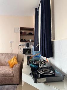 a kitchen with a stove top oven next to a couch at Cool Studios, Machakos in Machakos