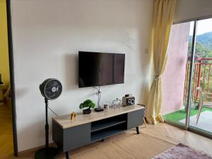 a living room with a flat screen tv on a wall at Yunis Cottage Tranquil mountain views Centrum Cameron Highlands in Brinchang