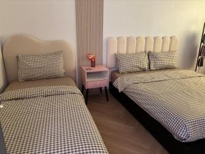 a bedroom with two beds and a night stand at Yunis Cottage Tranquil mountain views Centrum Cameron Highlands in Brinchang