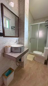 a bathroom with a sink and a toilet and a mirror at S&L Lodging House and Tampisaw Restaurant in Pandan