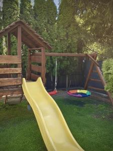 a playground with a slide and a swing at Apartamenty Bliza in Ostrowo
