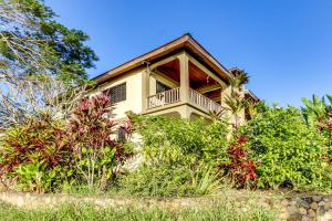 a house with a balcony on top of some bushes at Villa Maya in San Ignacio
