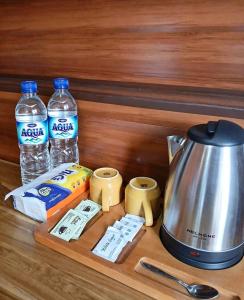a counter with a tea kettle and bottles of water at Bale Rinjani Lodge & Cafe in Tetebatu