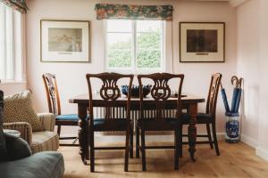 a dining room with a table and chairs at Two Cotswolds Cottages with Heated Pool in Tewkesbury