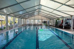 a large swimming pool with people in the water at Desert Iris Hotel in Yeroẖam +33 photos