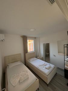 a bedroom with two beds and a mirror at Hotel SKURA , Librazhd in Librazhd