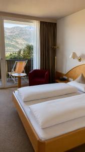a hotel room with two beds and a balcony at Hotel Braunsbergerhof in Lana +69 photos