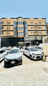 a parking lot with cars parked in front of buildings at فندق راحة السلام in Buraydah