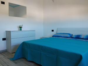 a bedroom with a blue bed and a dresser at L' Aurora Marina in SantʼAnna Arresi