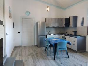 a kitchen with a table and chairs and a refrigerator at L' Aurora Marina in SantʼAnna Arresi