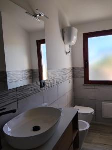 a bathroom with a sink and a toilet and a window at L' Aurora Marina in SantʼAnna Arresi +14 photos