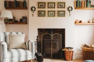 a living room with a couch and a fire place at Two Cotswolds Cottages with Heated Pool in Tewkesbury