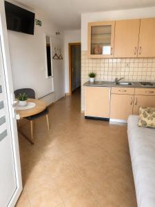 a living room with a table and a kitchen at Grabovica Sobe-Blue Lake Luxury Rooms in Grabovica