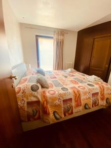 a bedroom with a bed with a comforter and a window at Casa Sole in Fenis