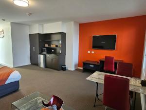 a hotel room with a bed and a desk and a tv at Robe Marina Accommodation in Robe +69 photos