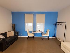 a living room with a blue wall and a table and chairs at Robe Marina Accommodation in Robe