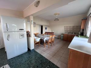 a kitchen with a white refrigerator and a table with chairs at Keszeg house in Szigetbecse