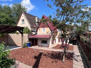 a house with a tree in the front yard at Keszeg house in Szigetbecse