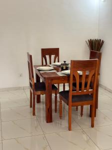 a dining room table with four chairs and a table and chairsktop at Luxury résidence Bassam in Moosou