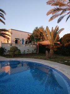 a swimming pool in front of a house at Darelkhir in Tazarka
